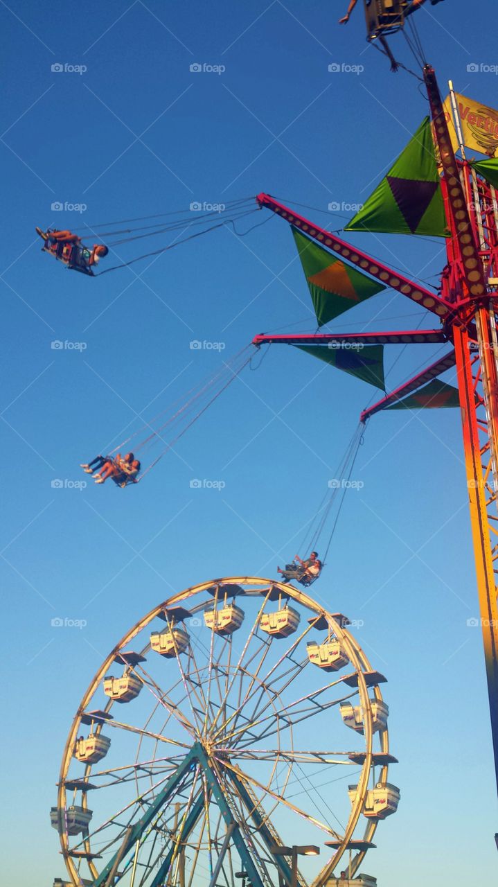 vertigo swing ride with view of ferris wheel at the back, fairgrounds