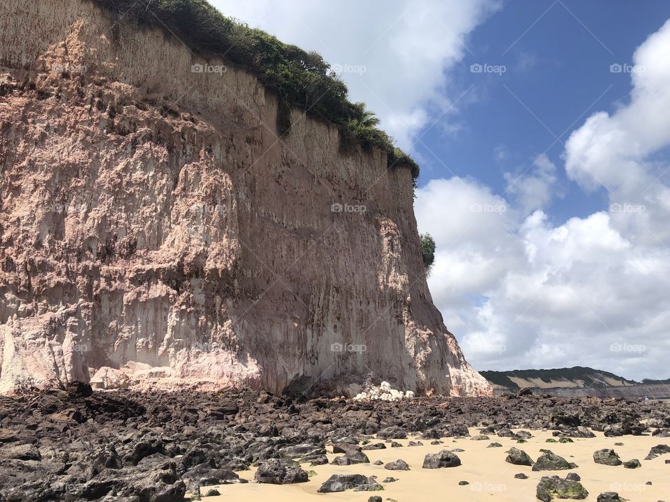 Cliff along the beach surrounded by rocks