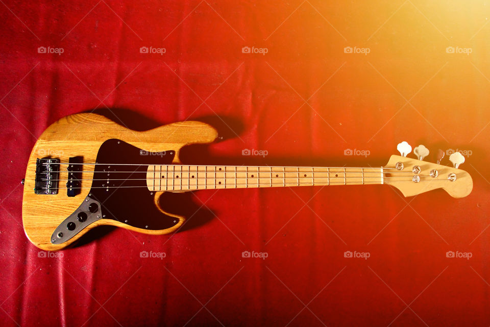 the bass guitar on red background