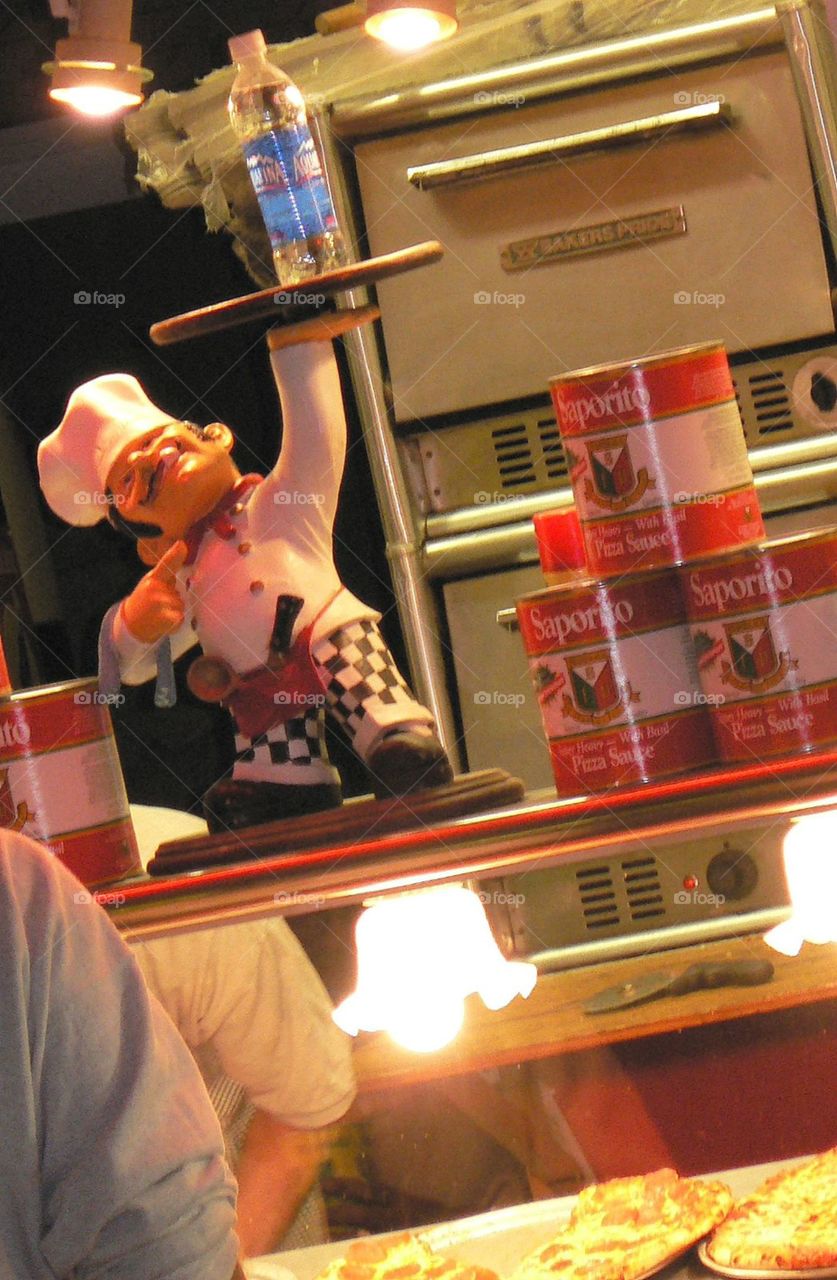 At your service . A cartoonish chef at a carnival food stand