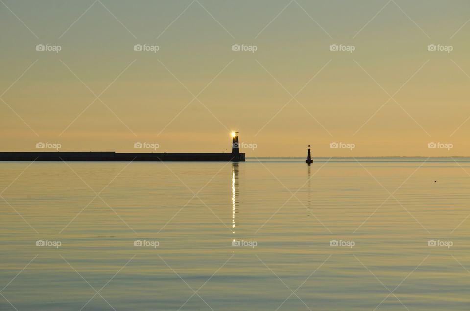 Sun reflecting in lighthouse during sunrise 