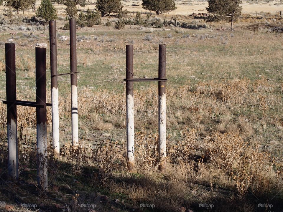 Old pipe frame in the ground showing the history of the area from abandoned industrial site converted to city park in Prineville in Central Oregon on a sunny winter day. 