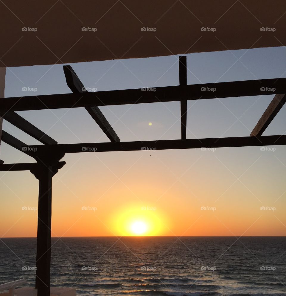 Sunrise through a window over the sea