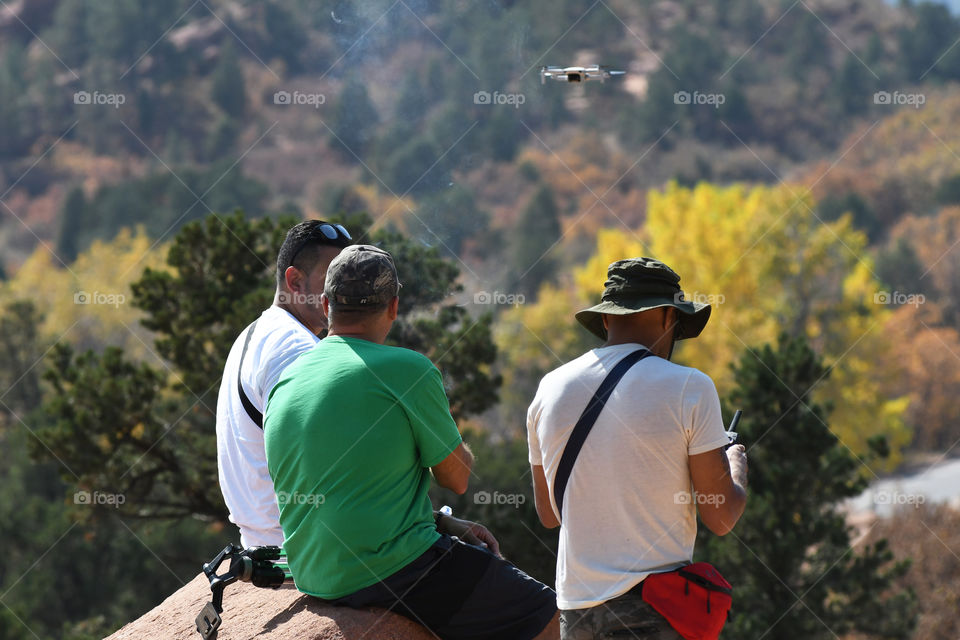 A group of friends enjoy a day out together on the rocky cliffs overlooking Colorado Springs at Garden of the Gods state park.