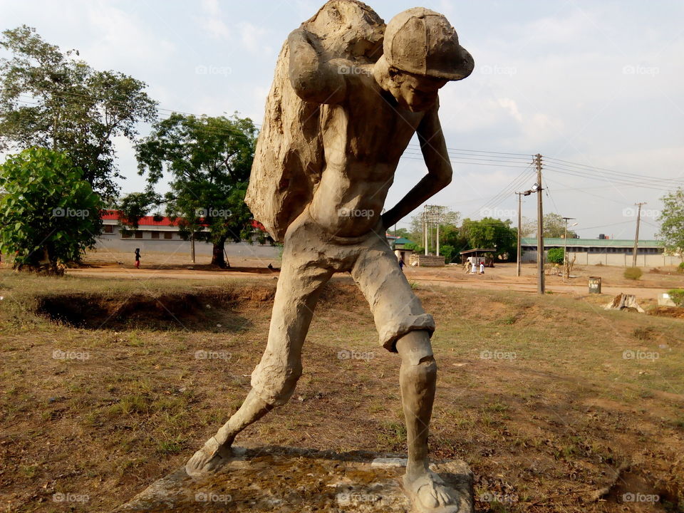African statue of man working loads
