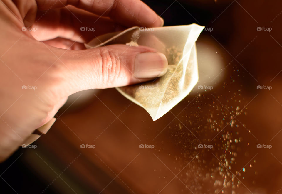 A person holding teabag