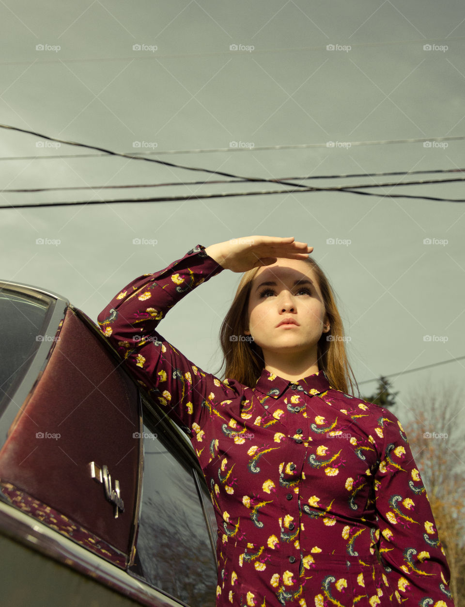 girl looking into distance with maroon dress