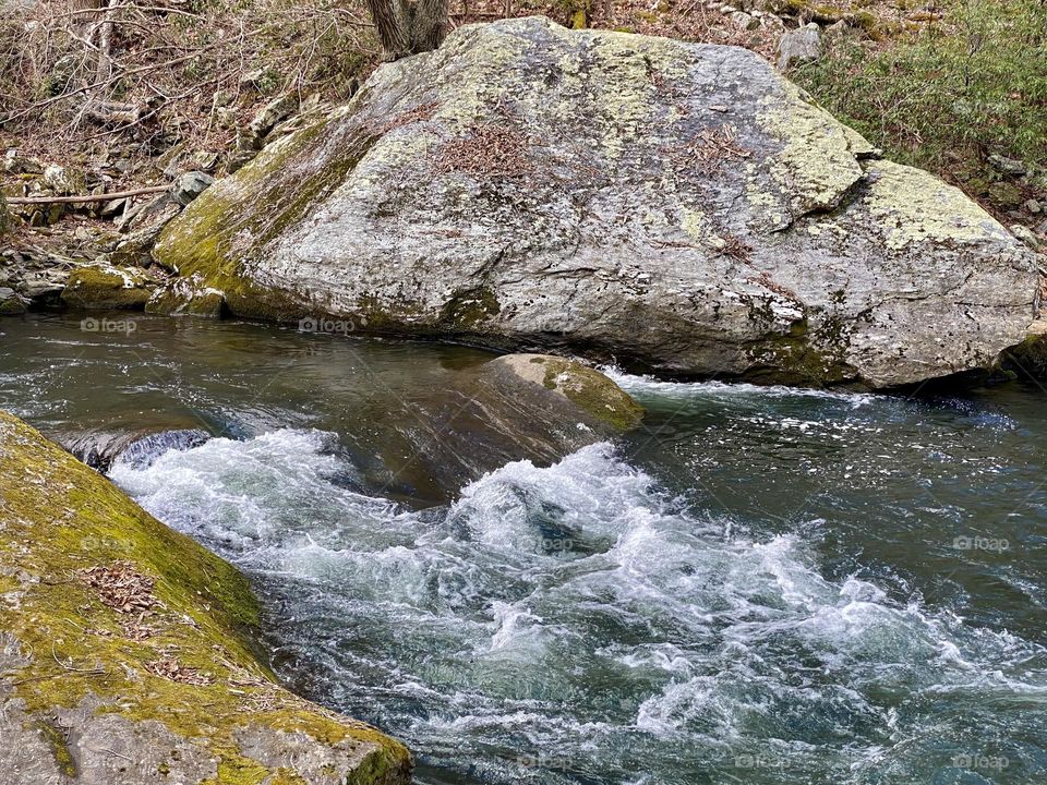 Large colorful rocks next to a river