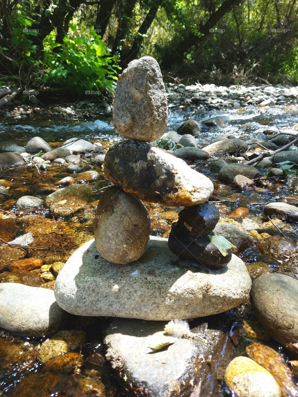 Creative Rockstack with the Rushing River Behund it on a Sunny Day