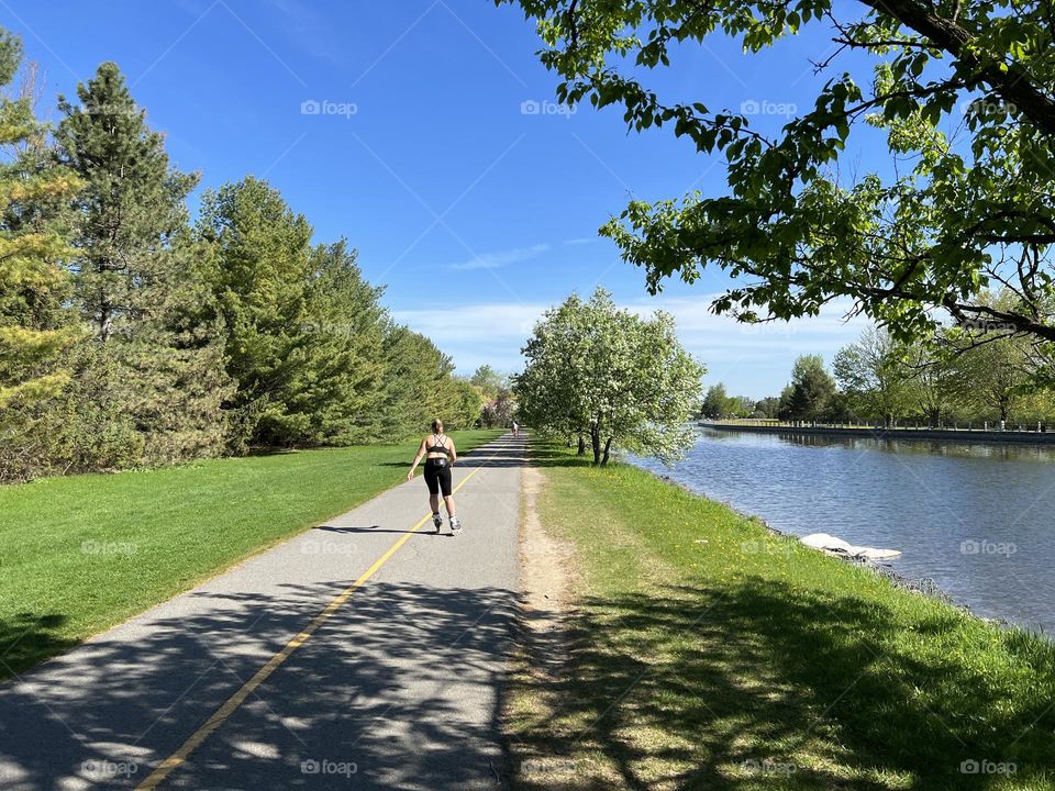 A person roller skating on the path near Rideau canal in Ottawa