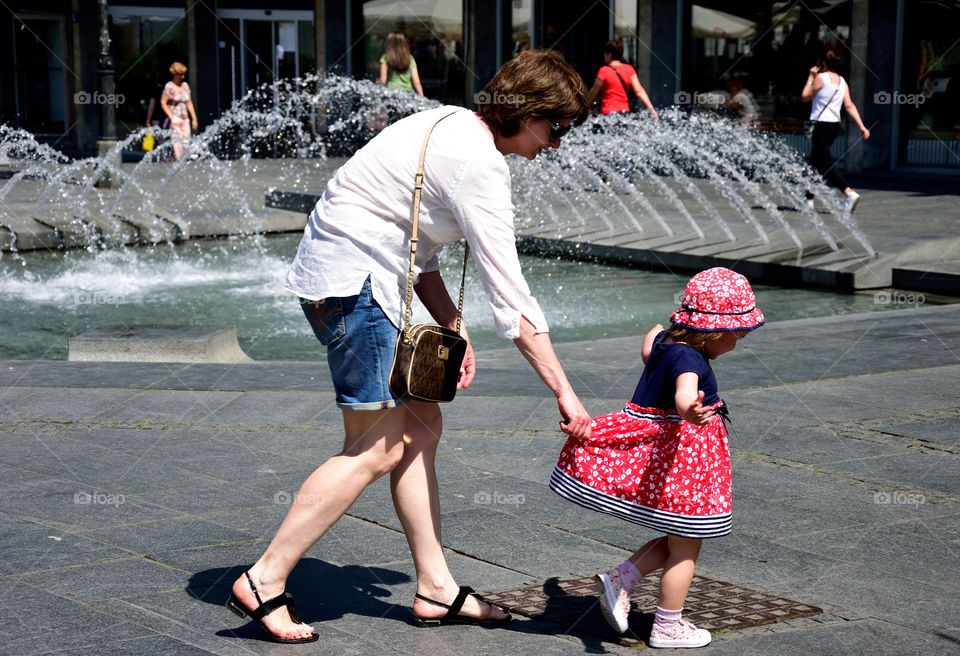 Mom playing with daughter near fountain
