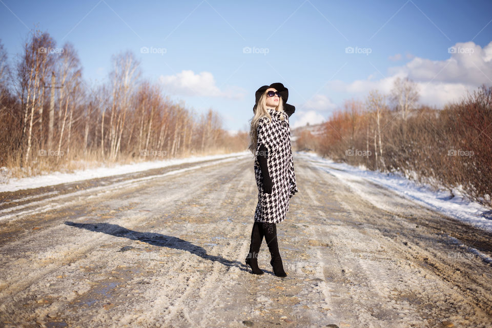 Young woman standing on dirt track