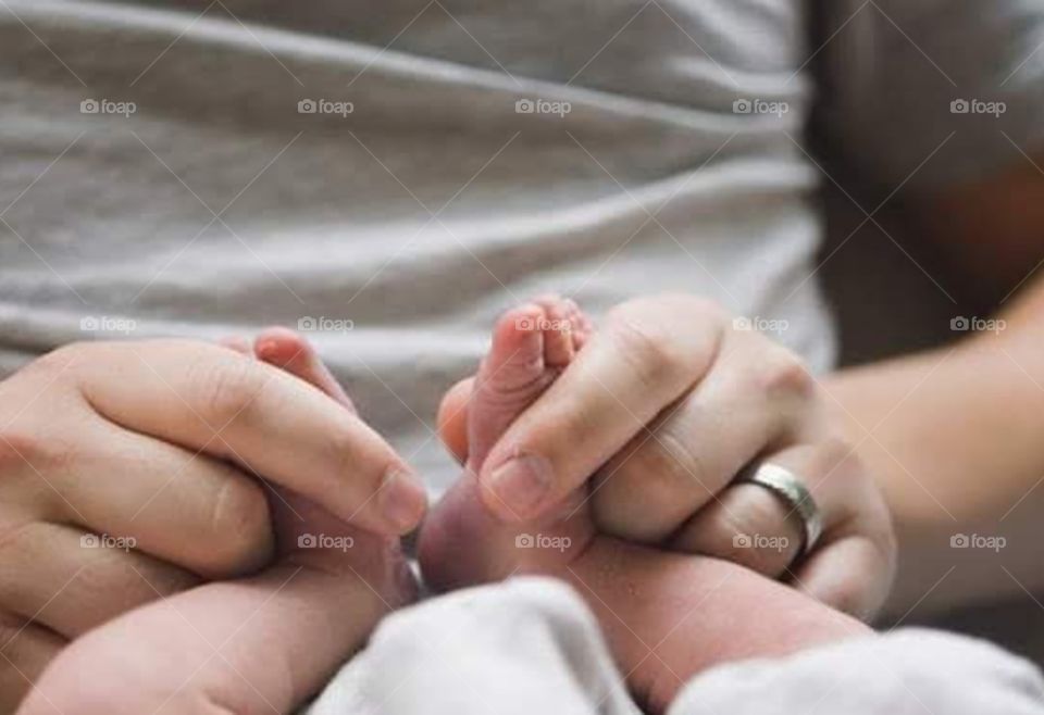 papa's hands massaging baby’s baby’s feet