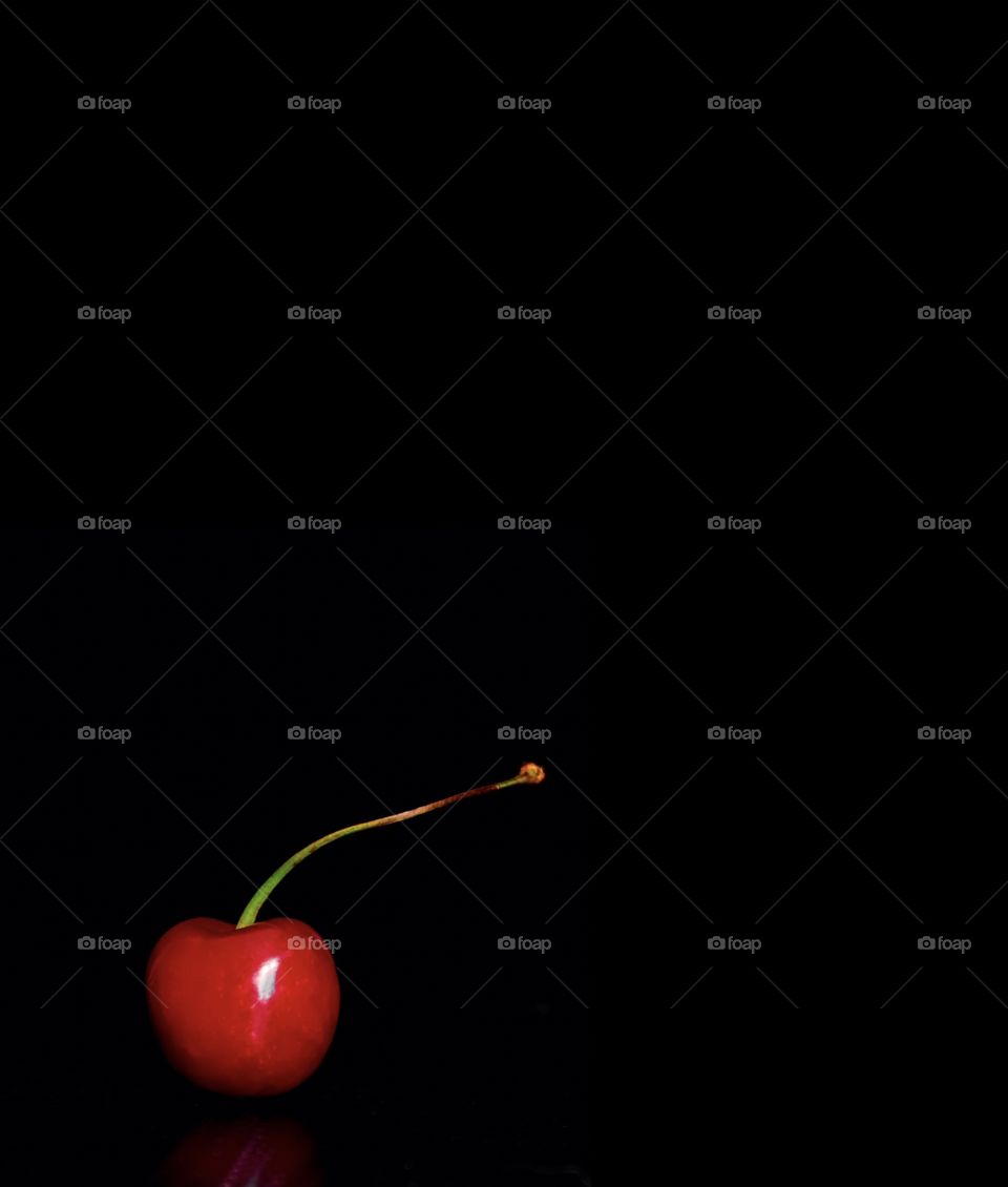 Red cherry, black background, minimalism 