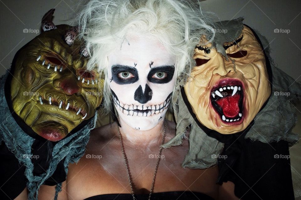 A young woman in Halloween face paint in the style of a skull between