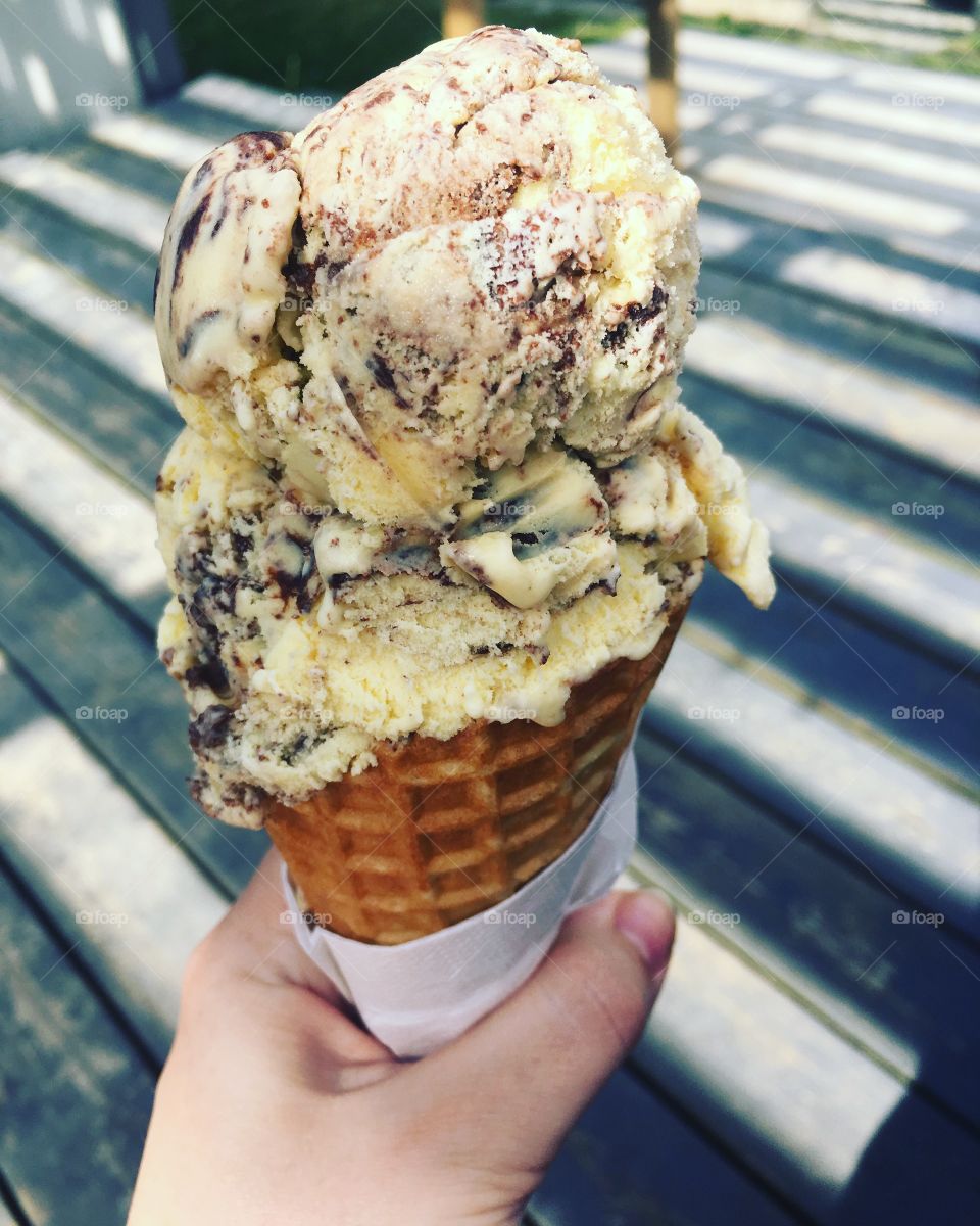 Hand holding vanilla ice cream cone