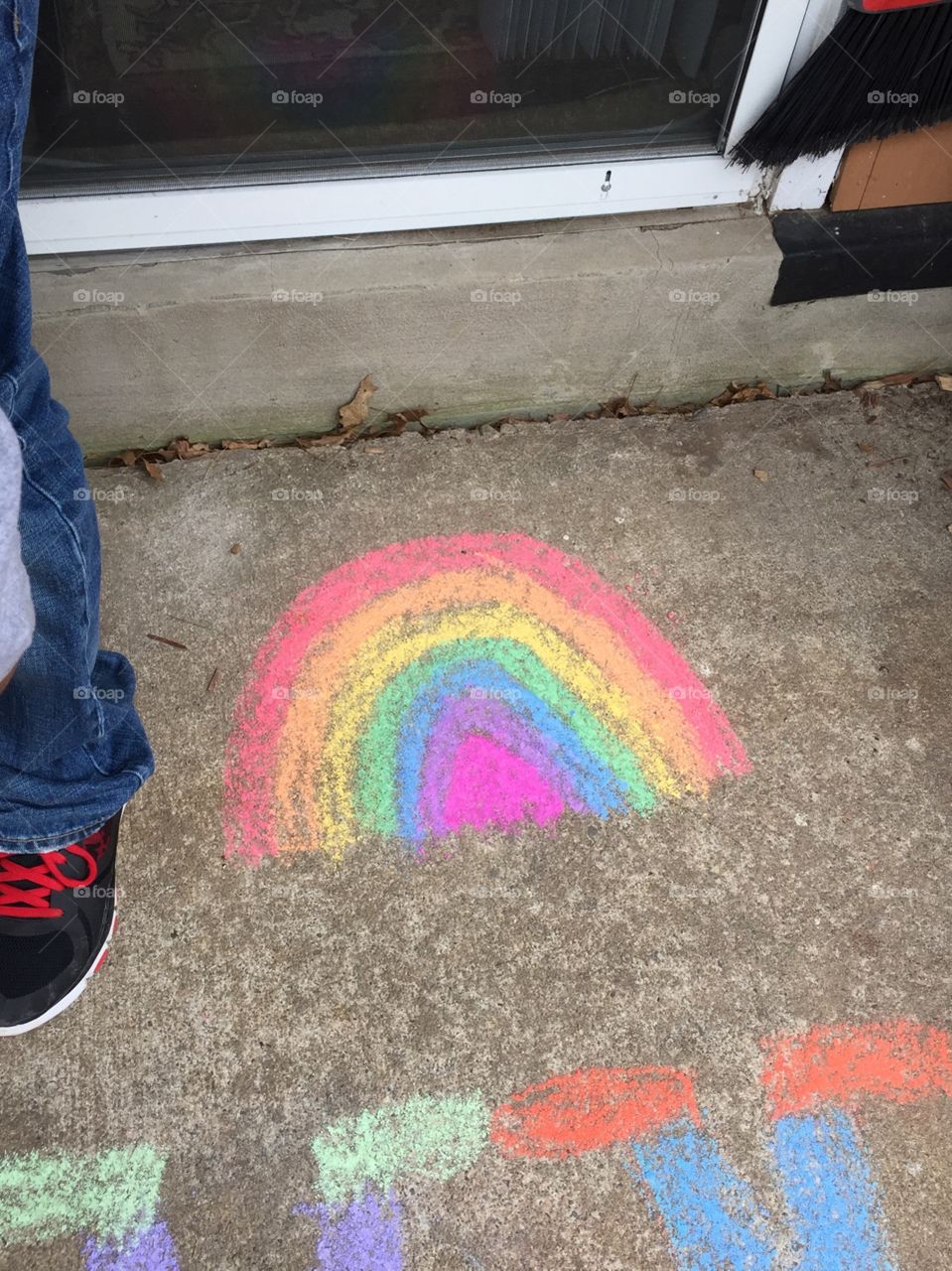Chalk drawing of a rainbow outside on the patio