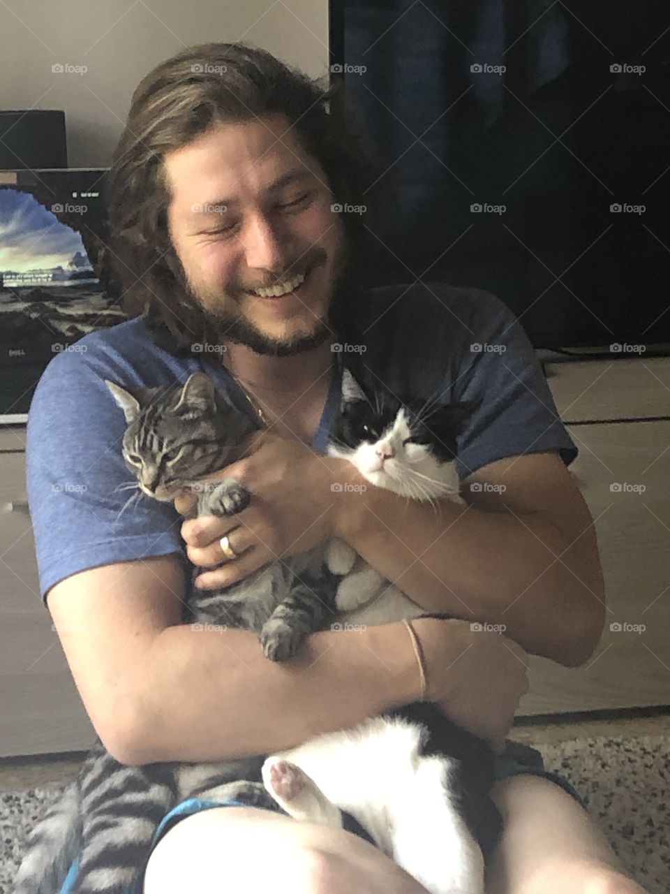 Um lindo homem feliz com seus gatos.