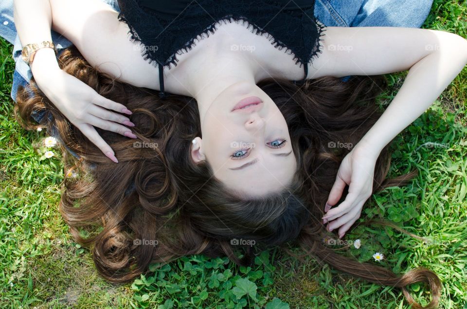 Portrait of a Beautiful Young Girl on Background of Daisies