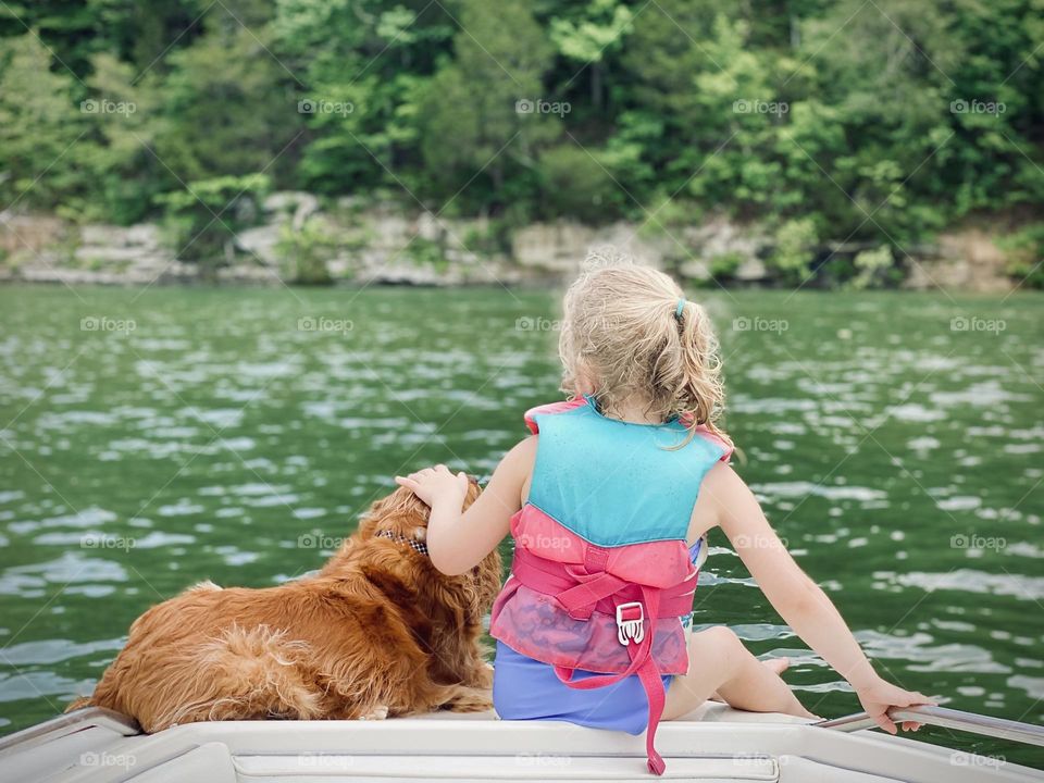 Just a girl and her dog sitting on a boat