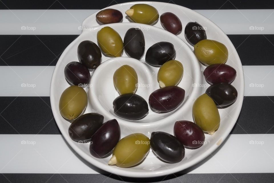Black and green olives in spiral dish