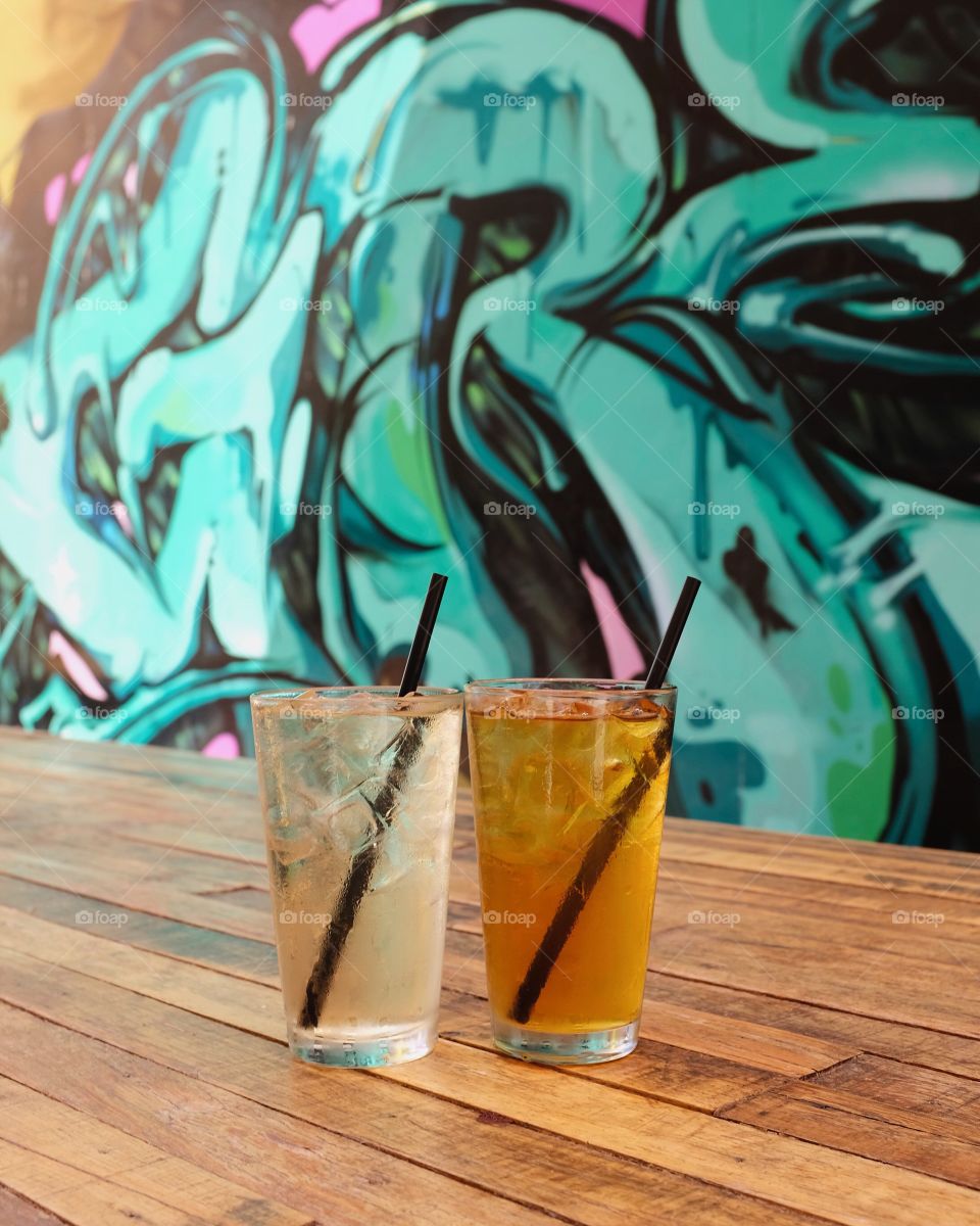 Iced tea next to the graffiti. 