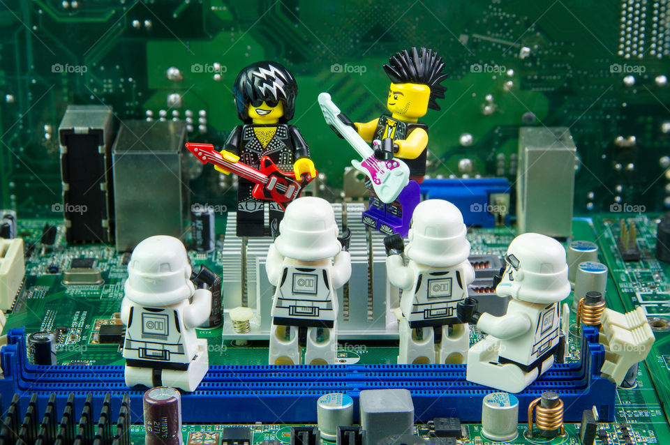 Lego rocker star singing concert on computer motherboard.