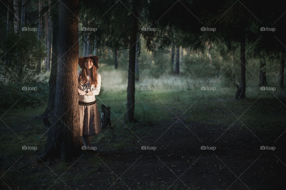 Portrait of Young woman in hat at evening park 