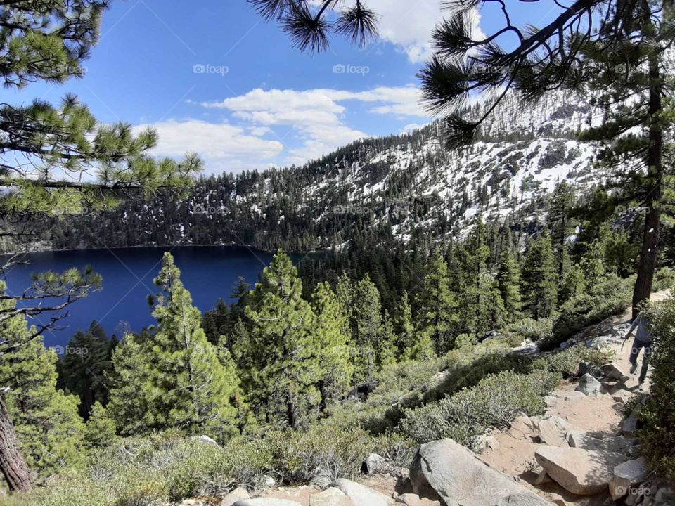 Hints of snow showing early signs of winter on the mountains full of coniferous pine trees around Lake Tahoe