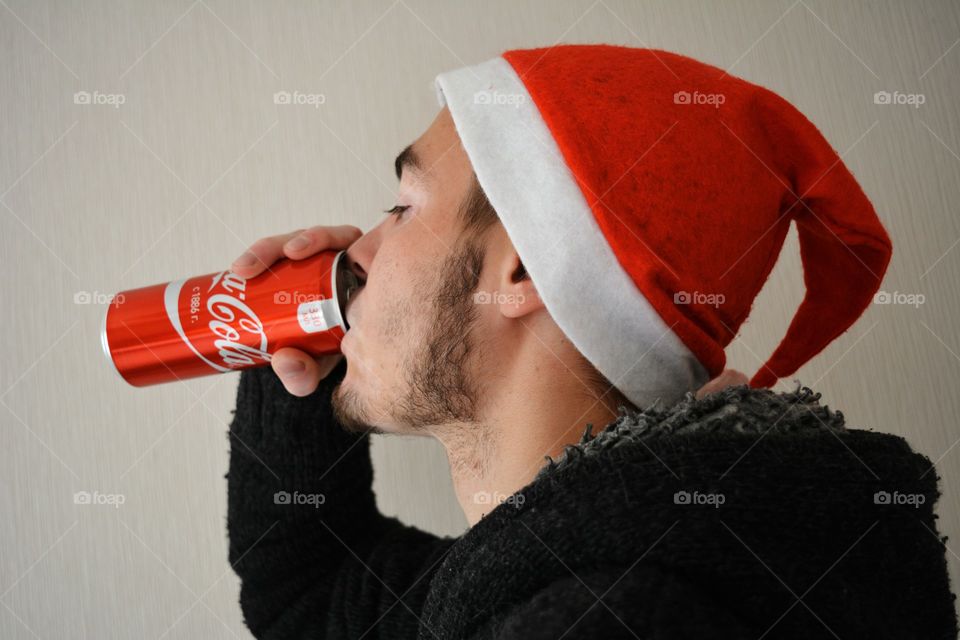 men in the red Christmas hat drinking coca cola