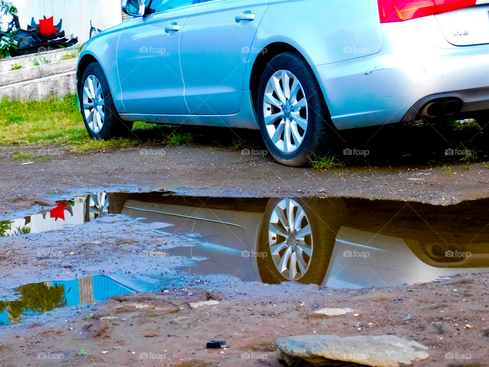 Reflection of standing car in water looking beautiful. The composition is attractive .