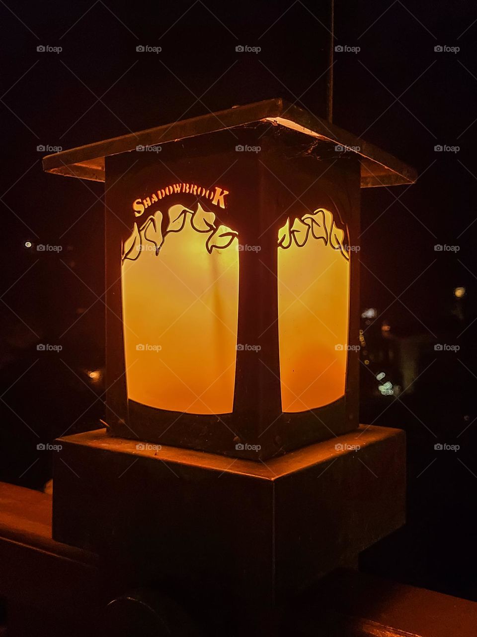 Glowing orange light illuminating from an outdoor lamp at shadowbrook restaurant in Capitola California on a cool evening on the patio 