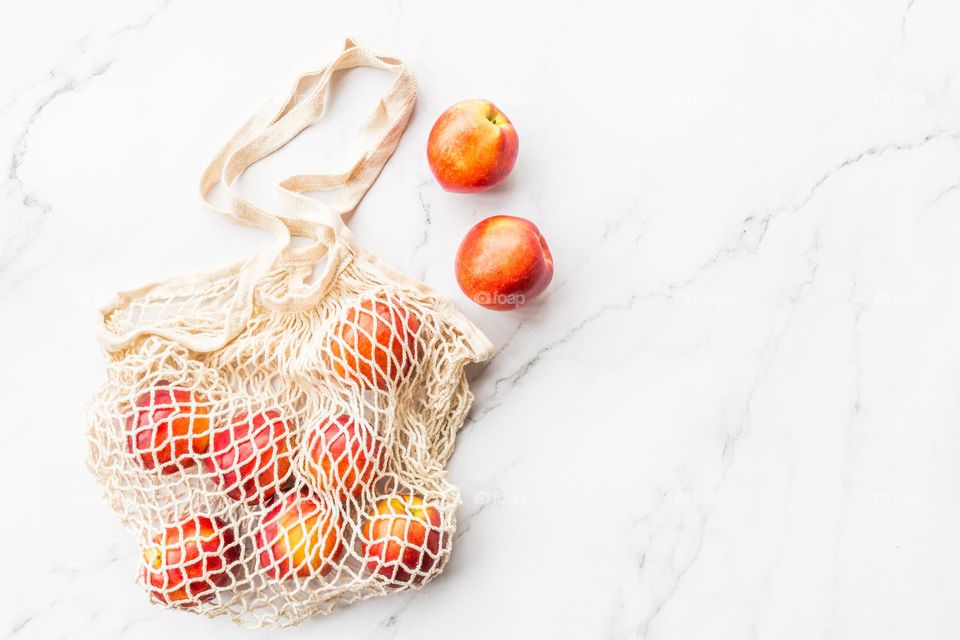 Fresh peaches in string bag