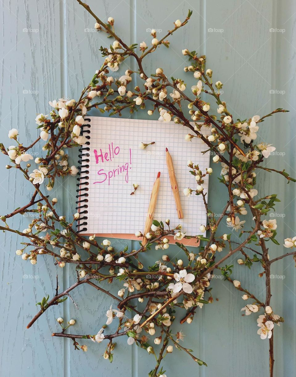 branches of flowering trees and a notebook with pencils.