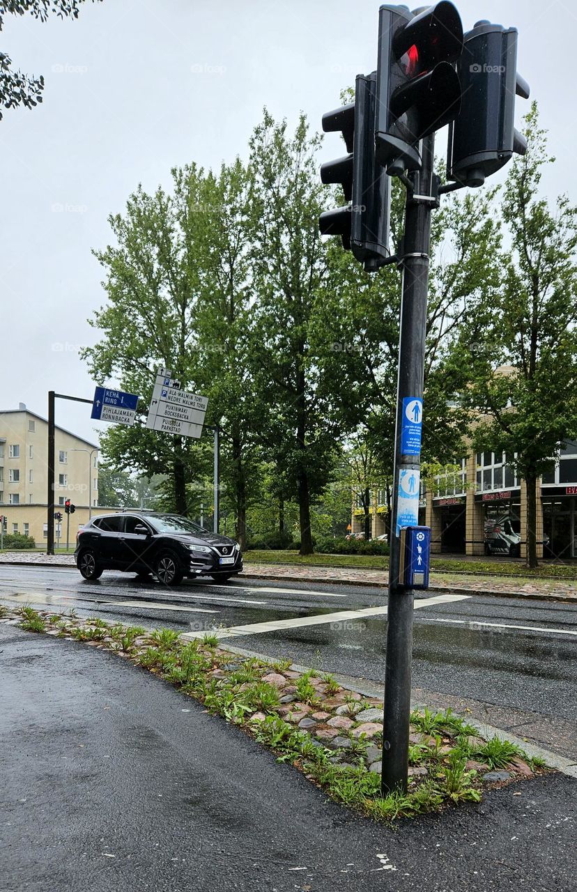 One black new car in traffic in Helsinki, the capital of Finland, in the Malmi district on a rainy day
