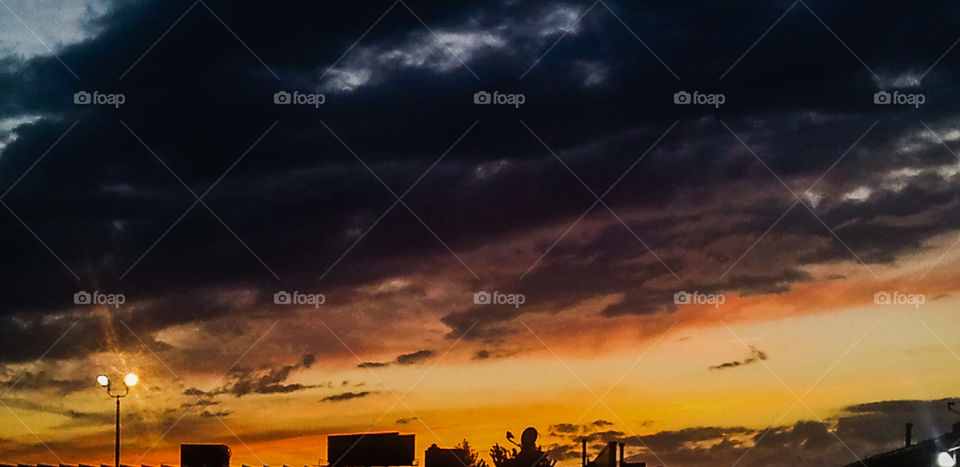 Burnt Clouds. A cloudy sunset after a rainstorm. This photo had some work done on it using the phone app Photoshop Express.