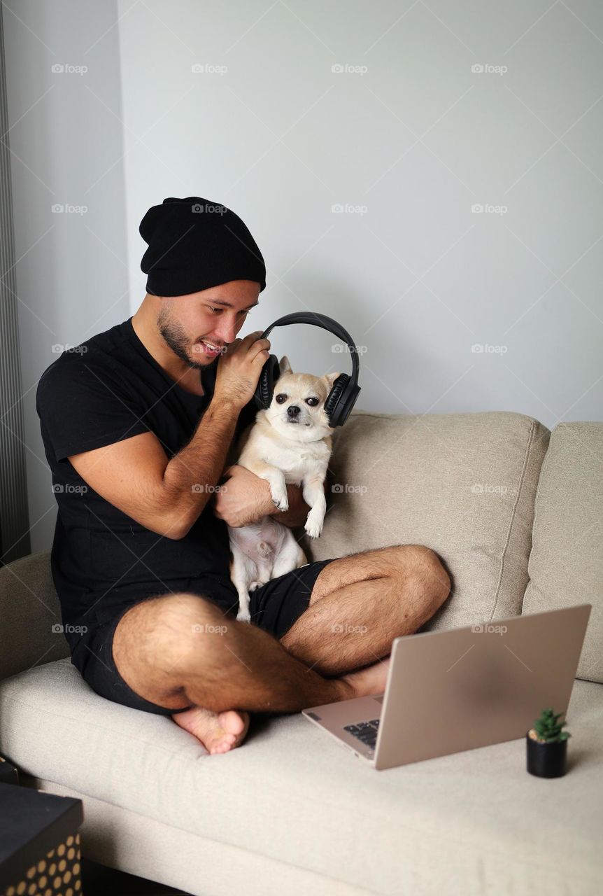 stylish guy in black clothes, with headphones and his best friend, a dog. a twenty-three-year-old teenager, a new generation.