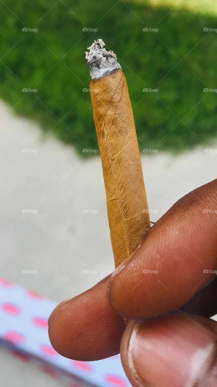 While smoking cigar with fresh mind at office.