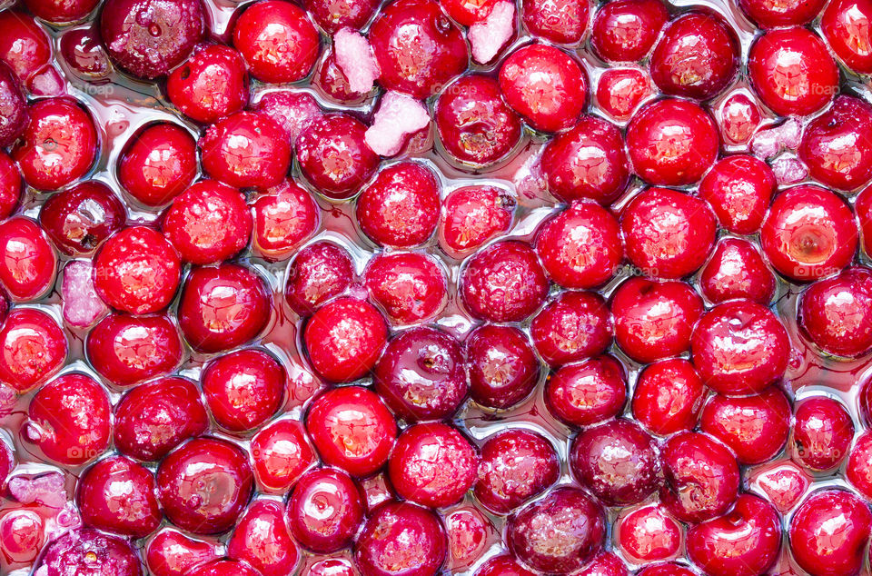 background of Cherry jam. Close up of simmering homemade cherry jam. Cherry and sugar crystal.