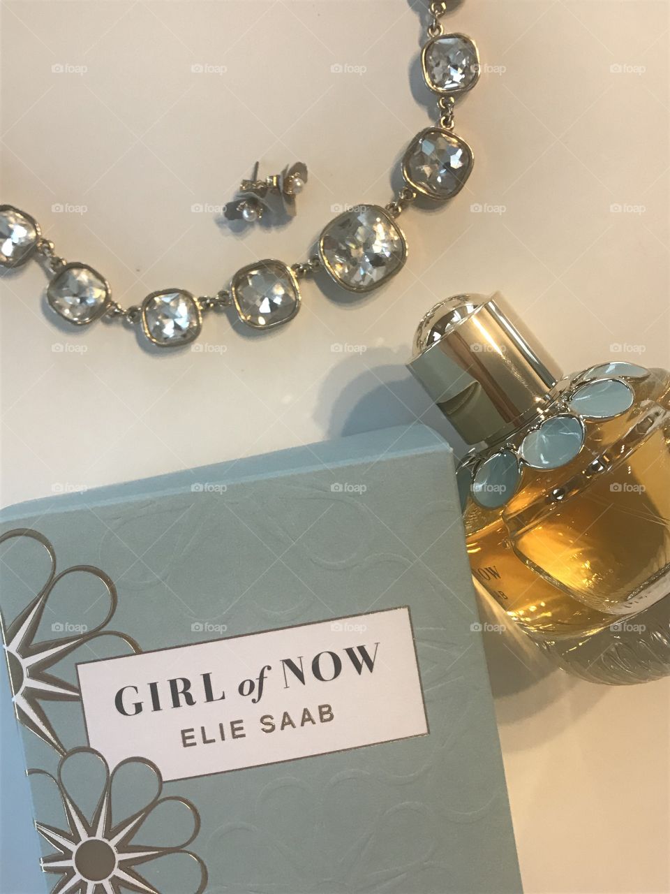 Perfume with jewelry with a blue and bright theme. Makeup and skincare look. 