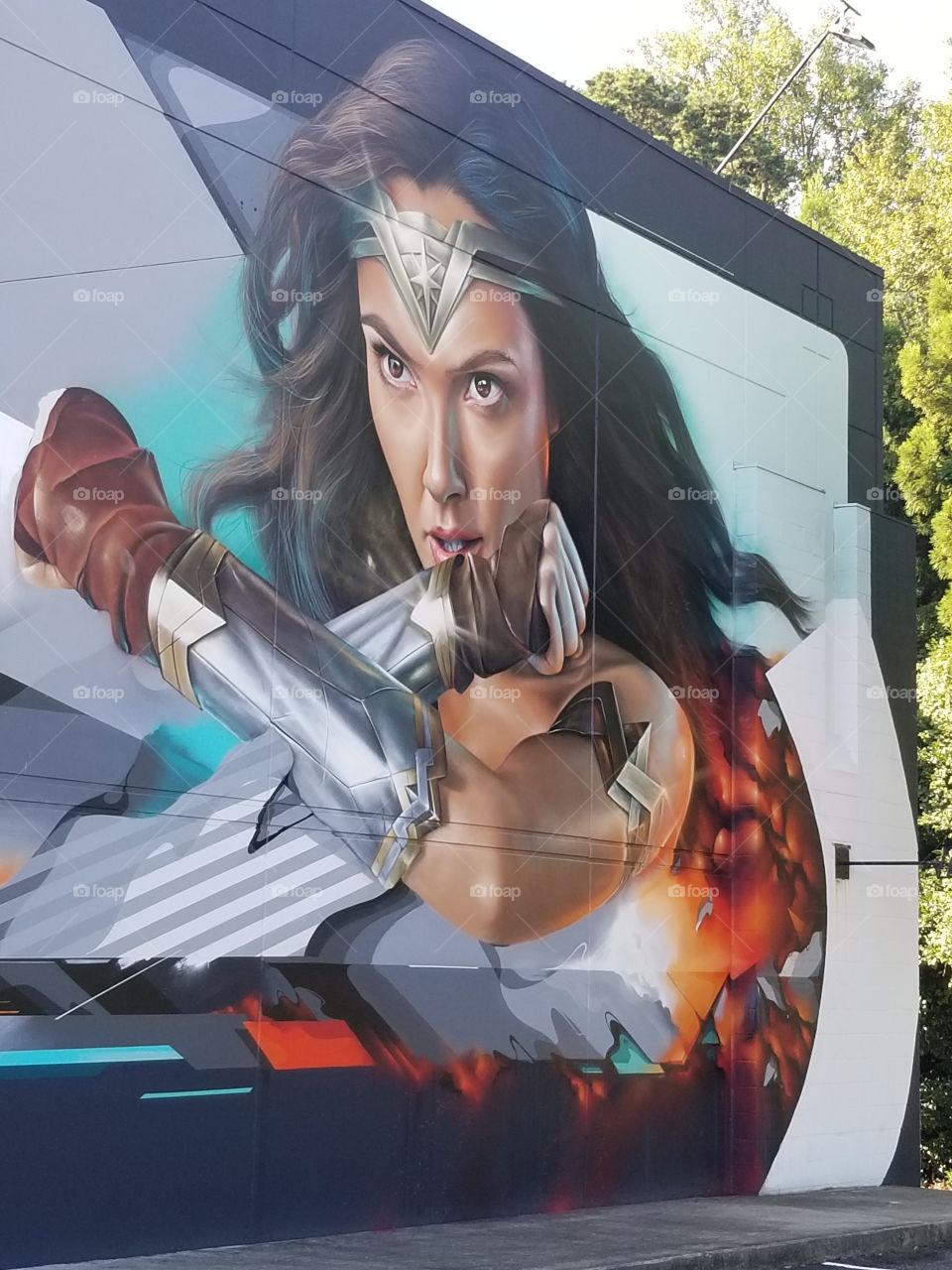 Closeup of wonder woman on building with trees on side on building beautiful.