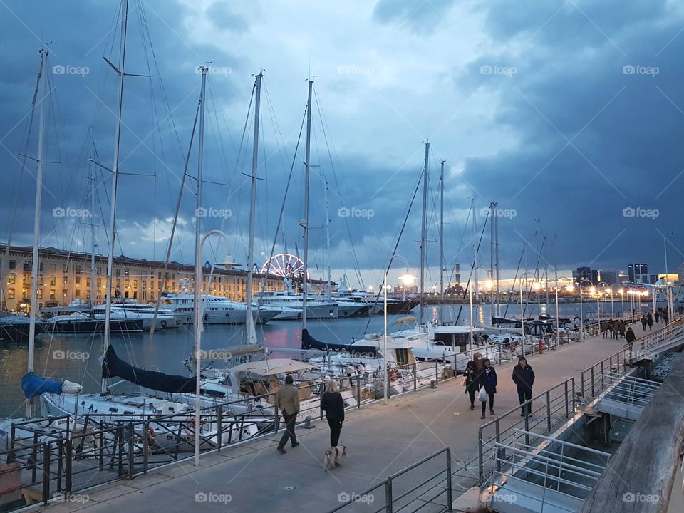 Walking people in the port of Genoa city at evening