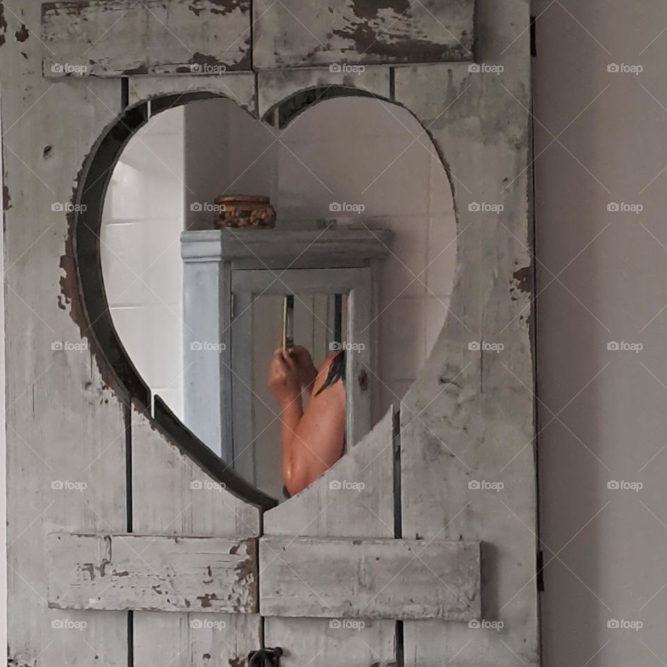 naked wer shoulder. 2 mirror reflection. heart shape grey shabby chic lady holding phone in shower