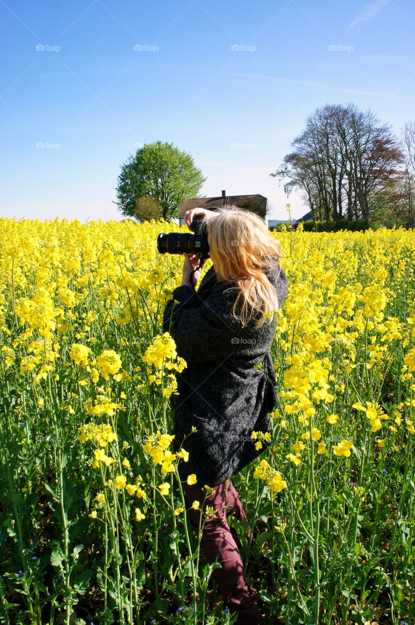 Woman taking photography of flower field