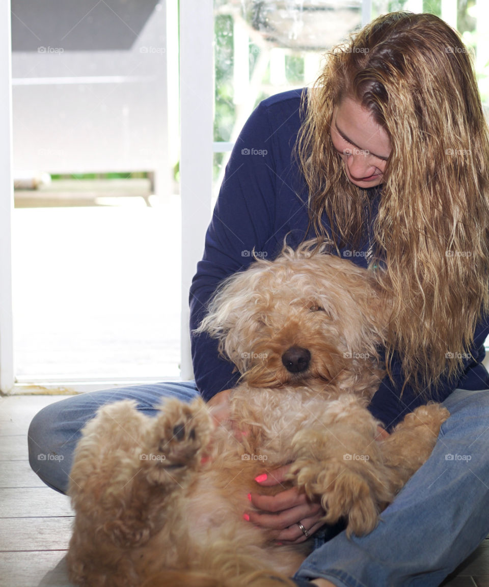 These fluffy cuddles always make me smile. Goldendoodle laying on woman with matching curling hair. 