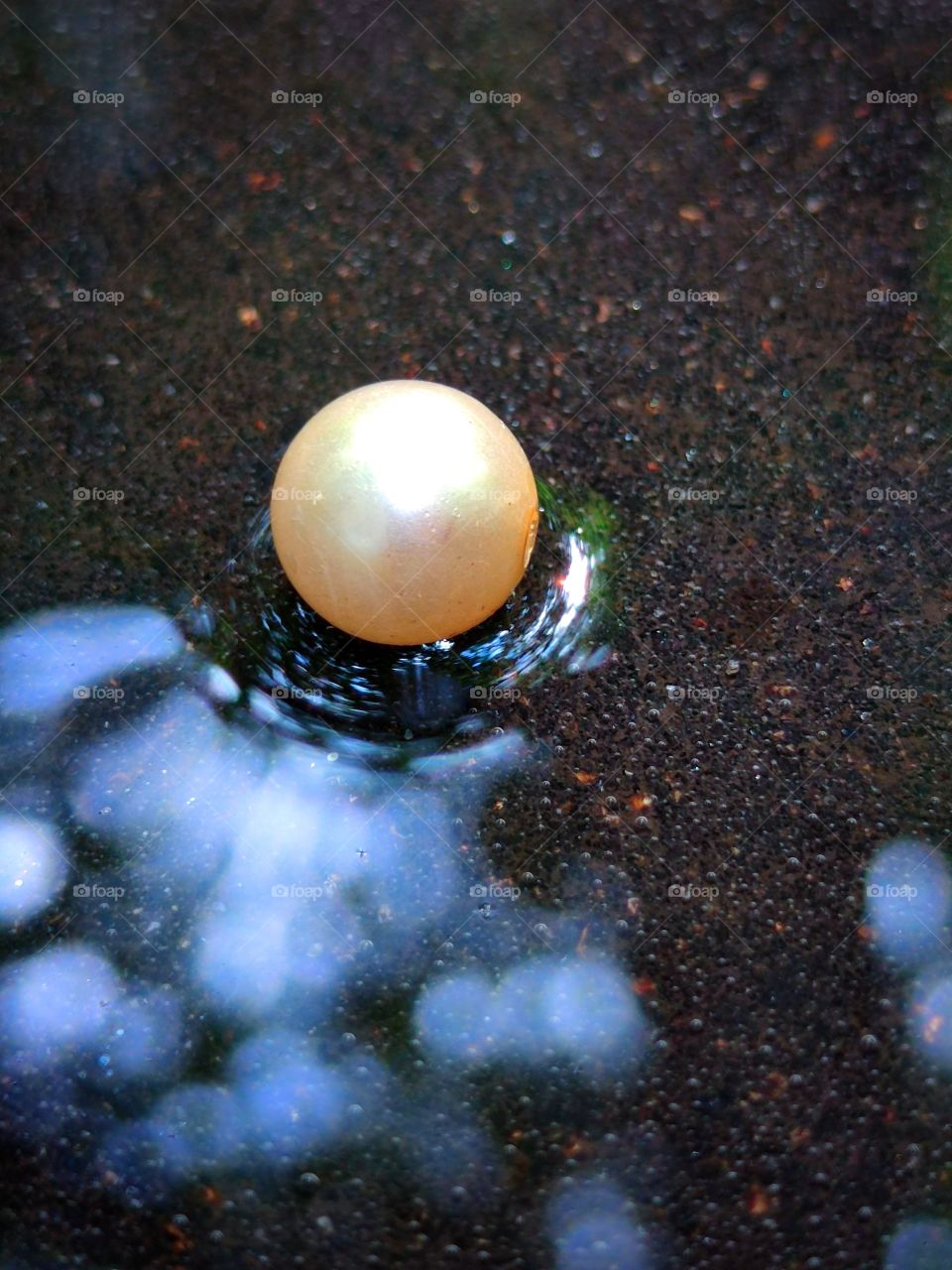 pearl on wet asphalt.  Multi-colored glare of wet asphalt from sunlight