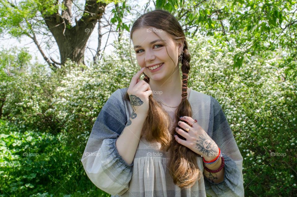 Portrait of Young Girl on Background of Flowers