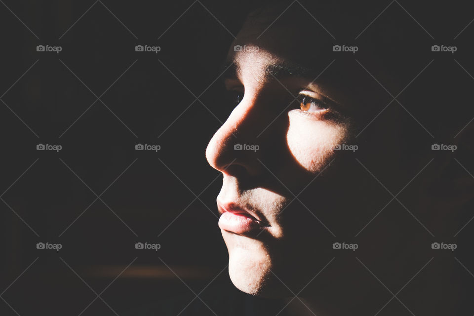 Young man's face cast in a strong shadow