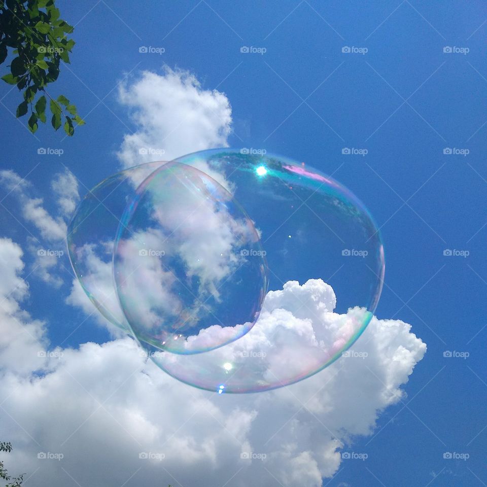 Мыльные пузыри на фоне неба. Полëт больших мыльных пузырей.