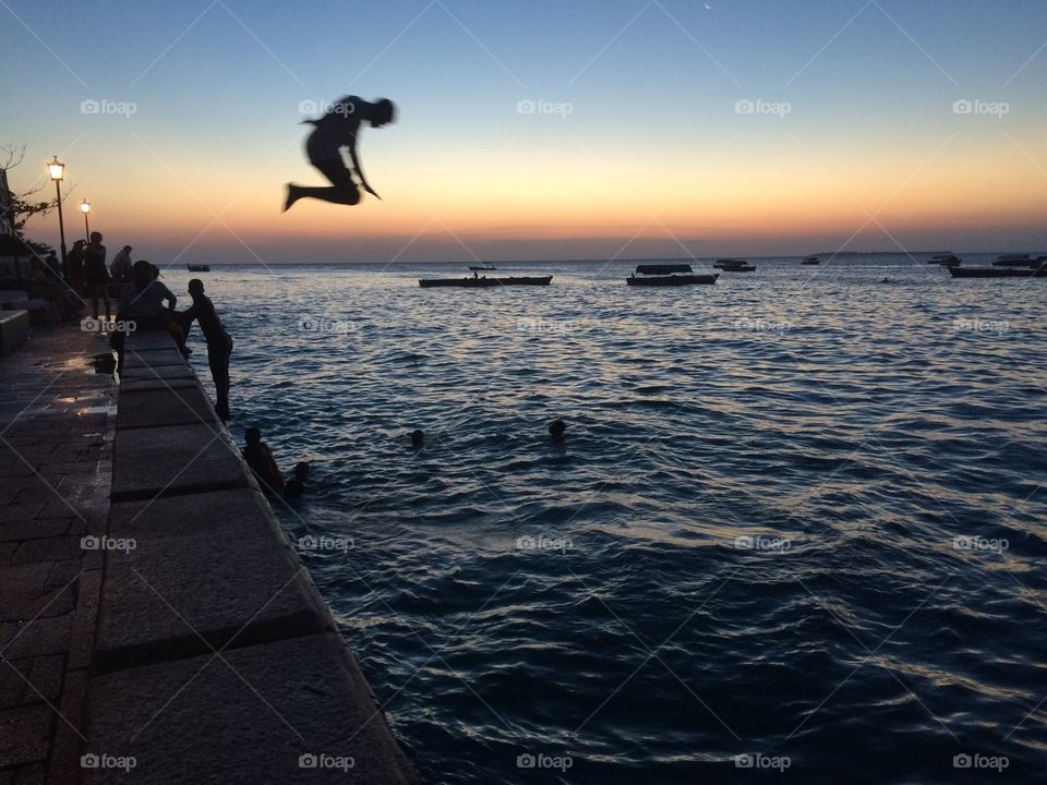Boy freestyle dives into ocean.